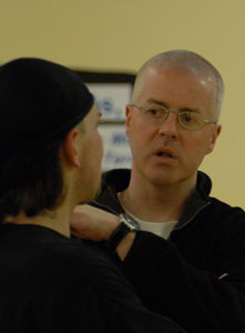 Fr. Obrien talks with teen at basketball practice